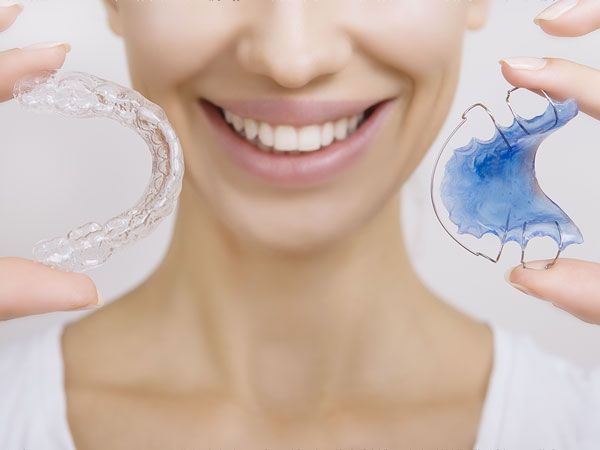 Manhattan Bridge Orthodontics girl holding Clear retainer and Hawley retainer